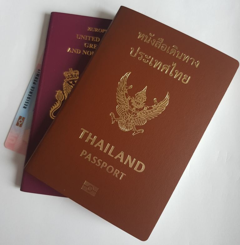 Photo of two a UK residence card, a UK passport and a Thai passport